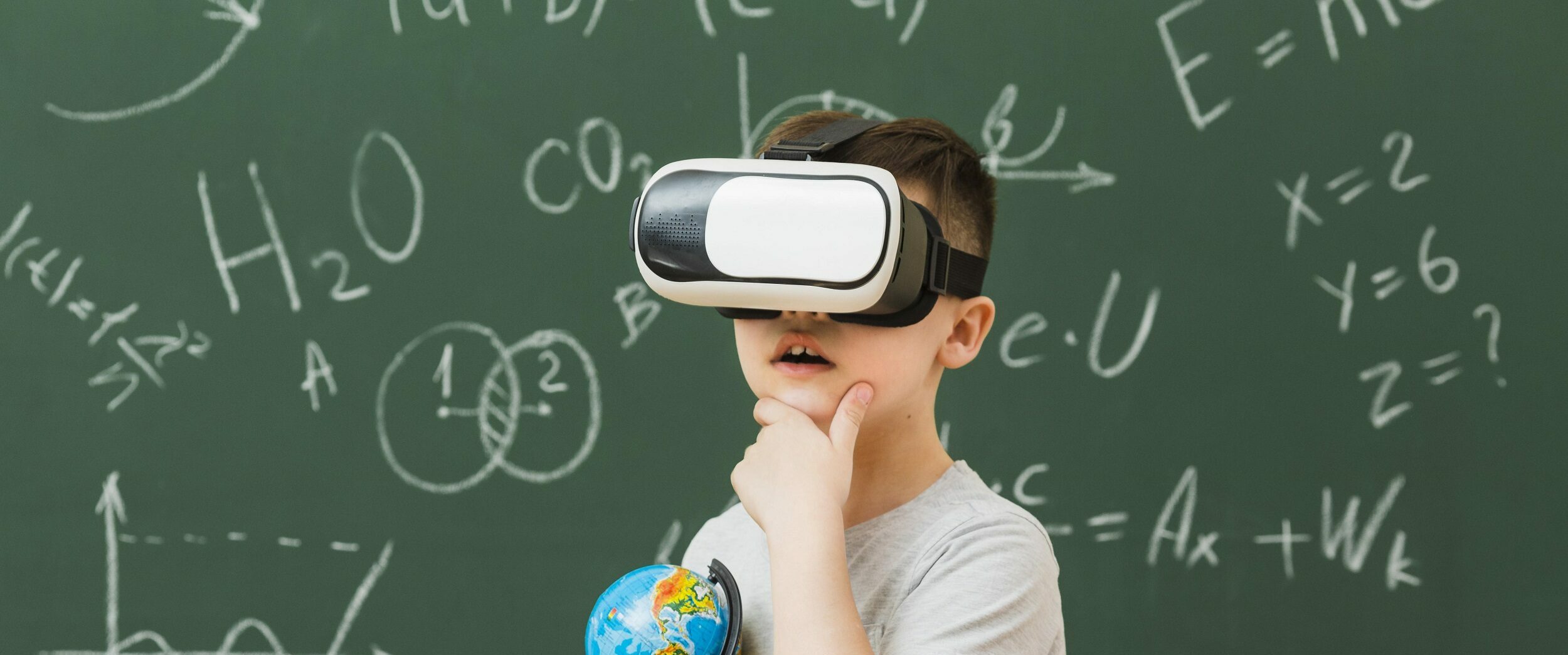 Criança usando óculos de realidade virtual e segurando livros e um globo terreste