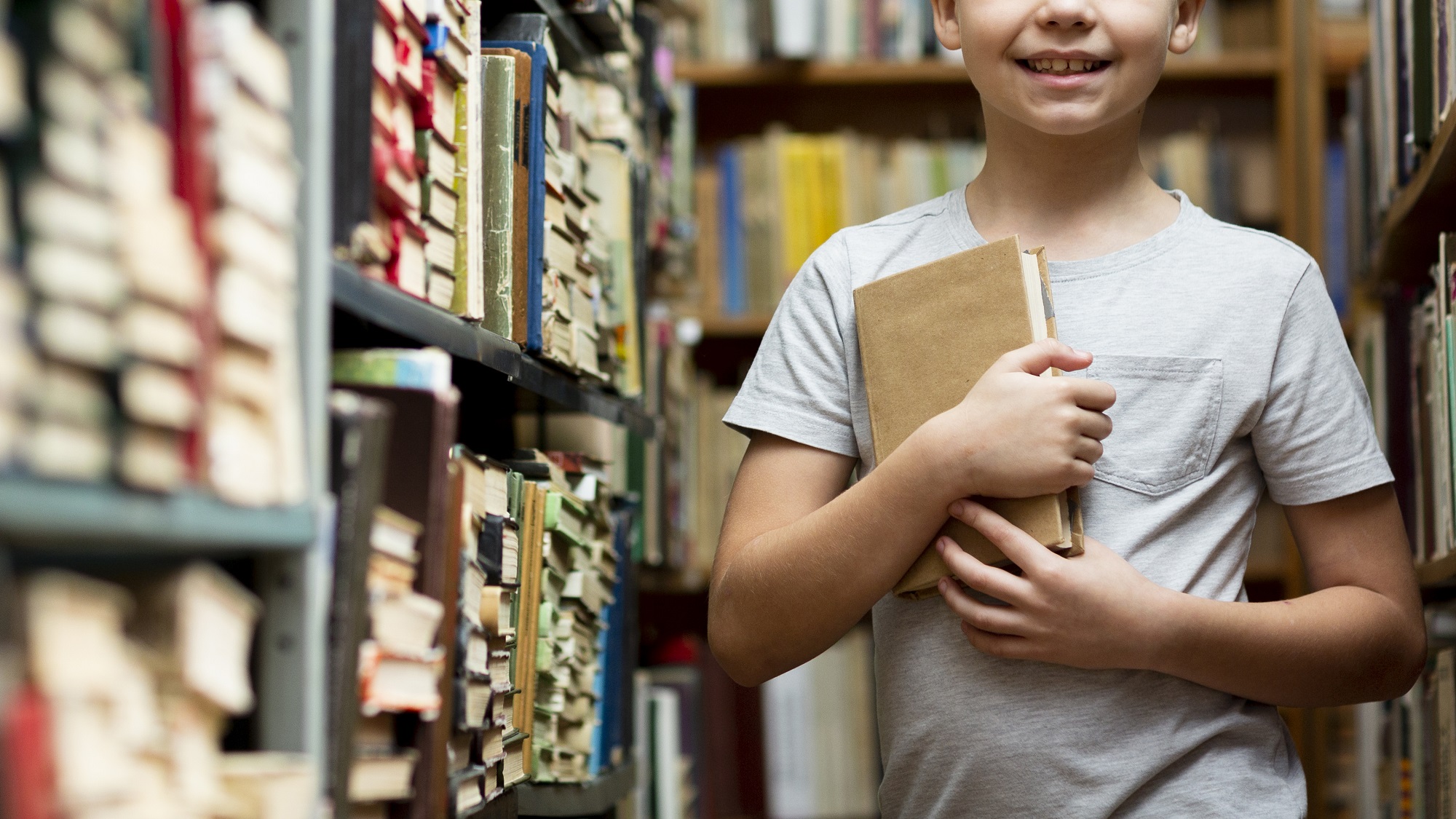 Imagem de Freepik mostra menino segurando livro